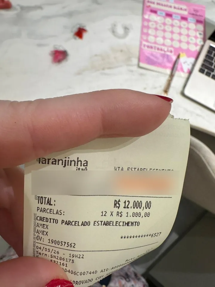 Comprovante de pagamento de R$ 12.000 em 12 parcelas, com os dados da clínica ocultados