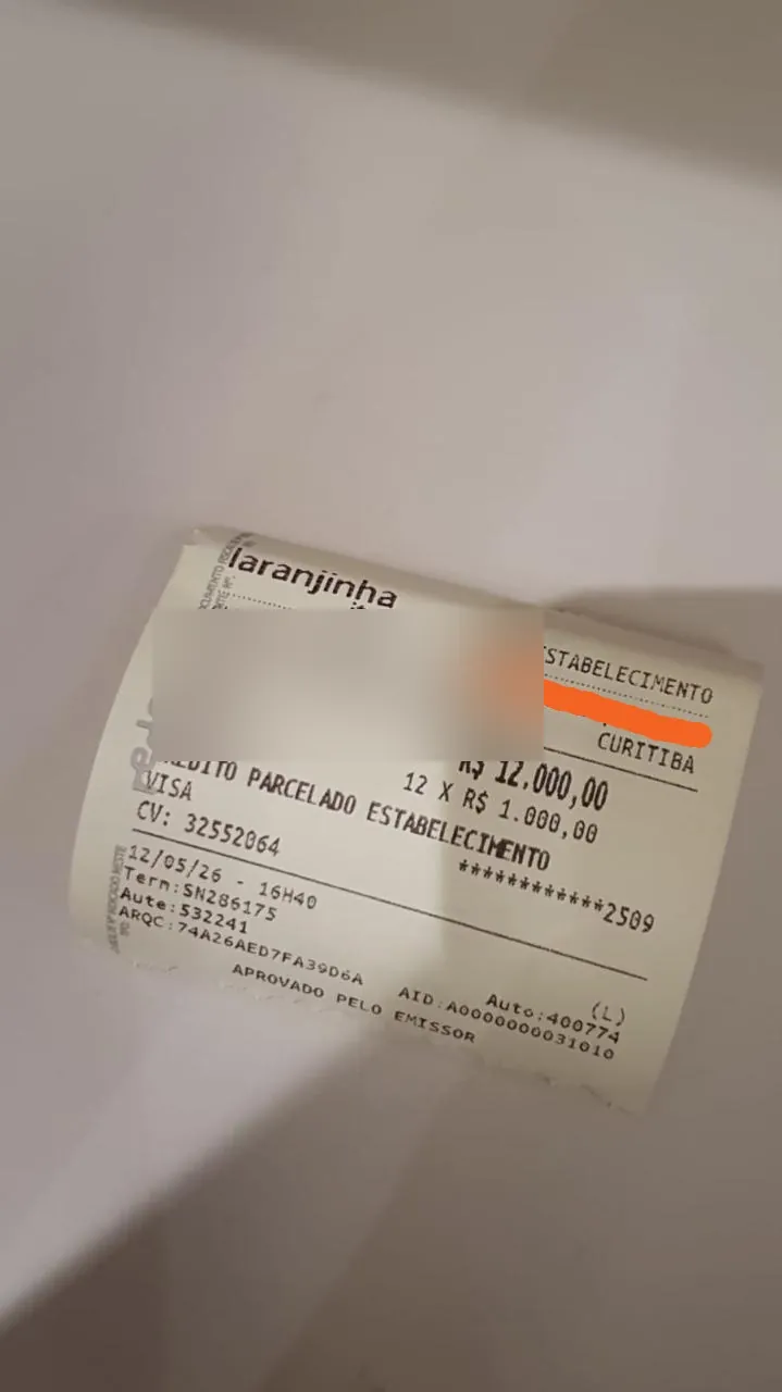 Comprovante de pagamento de R$ 12.000 em 12 parcelas, com os dados da clínica ocultados